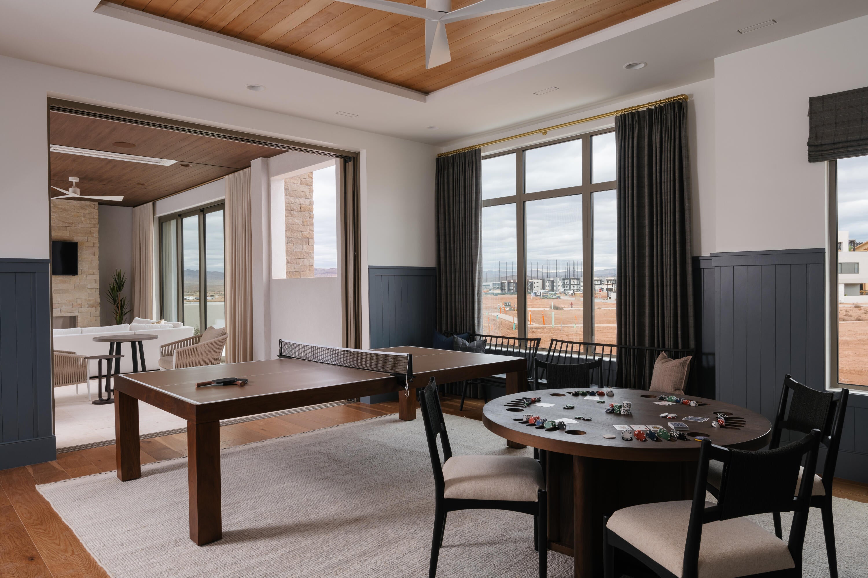 Recreation room featuring wood-finish flooring, wainscoting, and large windows with outdoor scenery