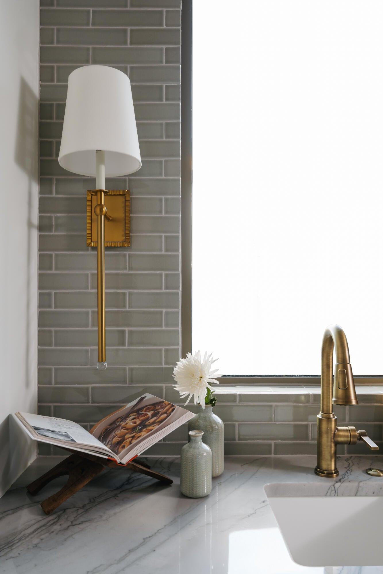 Polished countertop with a marbling pattern, featuring an undermount sink and a brass-finish gooseneck faucet