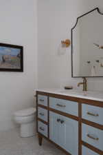 Bathroom vanity featuring blue-painted cabinetry and wood-finish framing