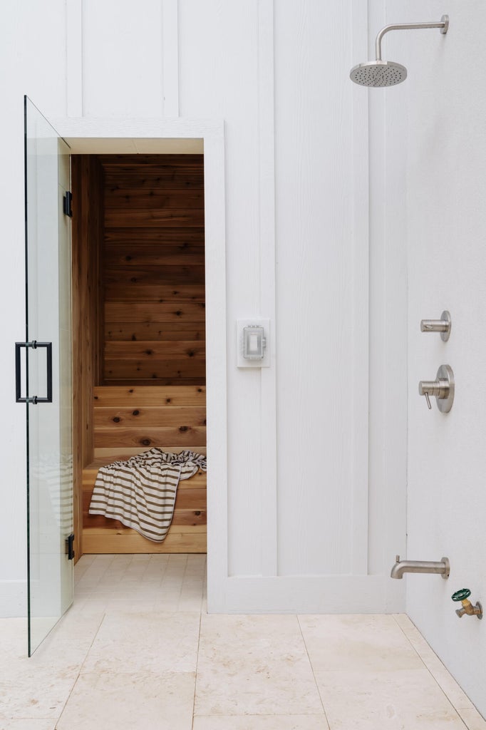 Sauna room with wooden bench seating and a clear glass door