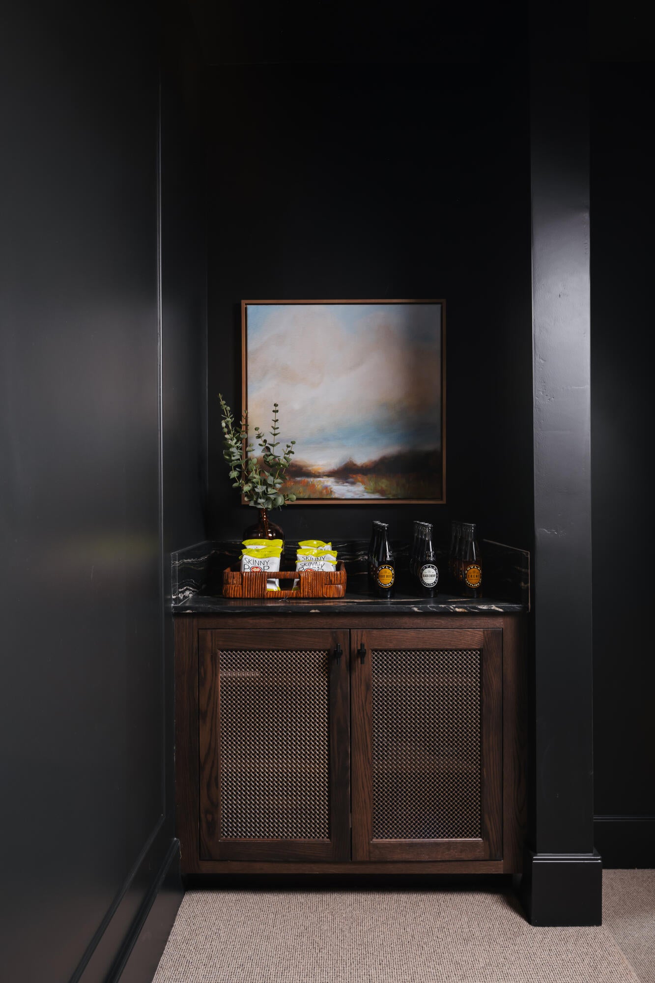 Custom built-in cabinetry featuring perforated metal door panels, a dark stone countertop, and a built-in backsplash