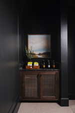 Custom built-in cabinetry featuring perforated metal door panels, a dark stone countertop, and a built-in backsplash