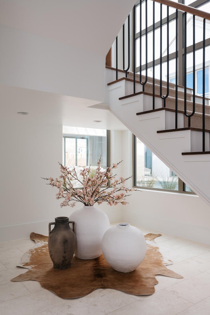 Staircase featuring dark wood treads, white risers, and black metal balusters with a wood handrail