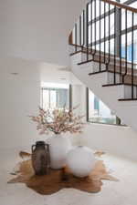 Staircase featuring dark wood treads, white risers, and black metal balusters with a wood handrail