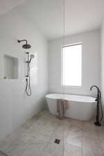 Spacious bathroom featuring a freestanding soaking tub with a floor-mounted matte black faucet