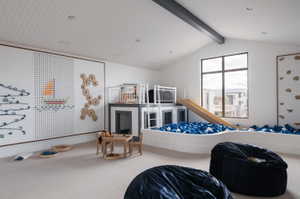 Spacious bonus room featuring a vaulted ceiling with exposed beam, recessed lighting, large multi-pane window, and light-toned carpeting