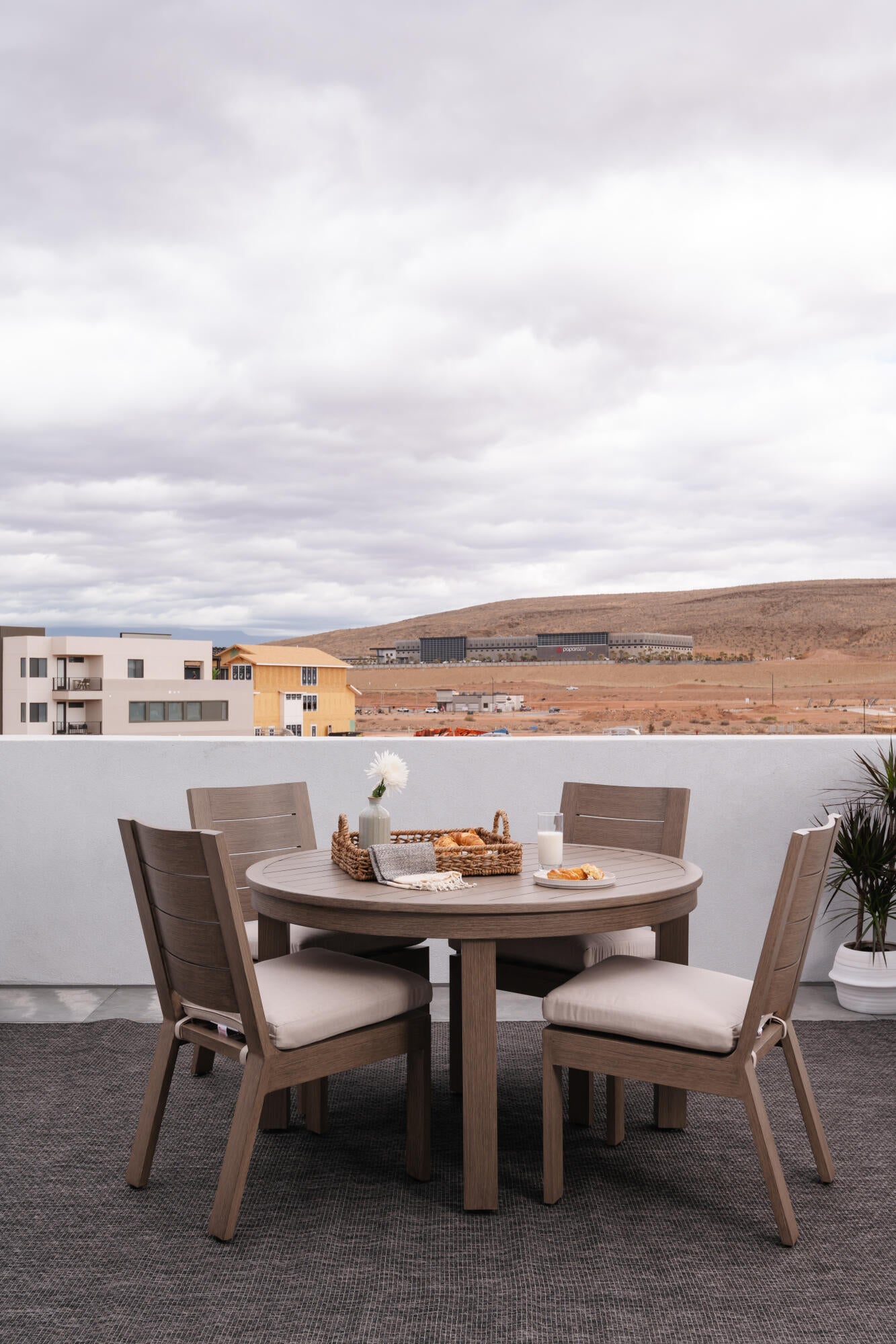 Spacious rooftop deck featuring a low-profile perimeter wall, textured outdoor carpeting, and distant desert hills