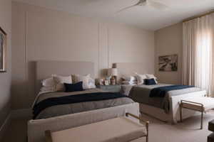 Carpeted room featuring panel molding, a modern ceiling fan, and full-height window drapery