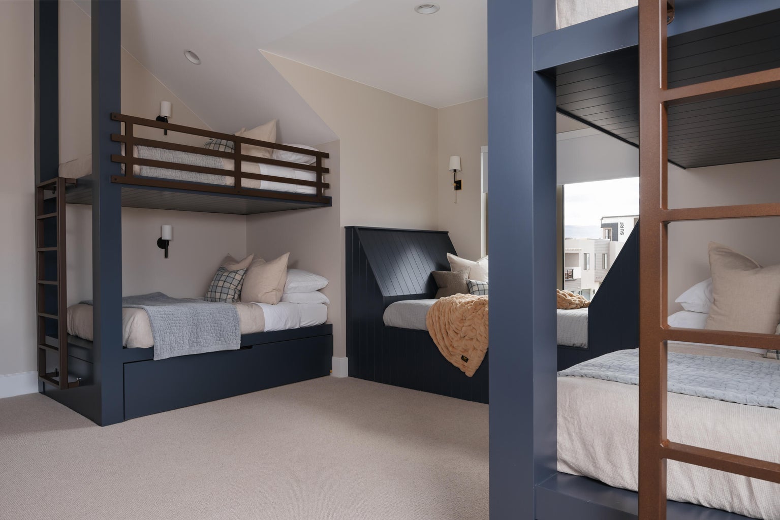 Built-in bunk beds with integrated storage drawers, slatted headboards, and wall-mounted sconces