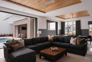 Expansive living area featuring large sliding glass doors opening to an outdoor patio with a swimming pool