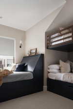 Built-in bed frames with integrated storage, neutral-toned carpeting, recessed ceiling lighting, and wall-mounted sconces