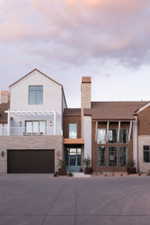 Contemporary facade featuring mixed materials including white stucco, natural wood shingle siding, and stacked stone accents