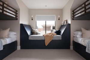 Built-in window seat with a paneled base, flanked by two wall-mounted bunk beds featuring dark wood frames and integrated storage drawers