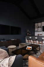 Integrated bar area featuring a stone countertop, built-in shelving, and dark-stained wood flooring