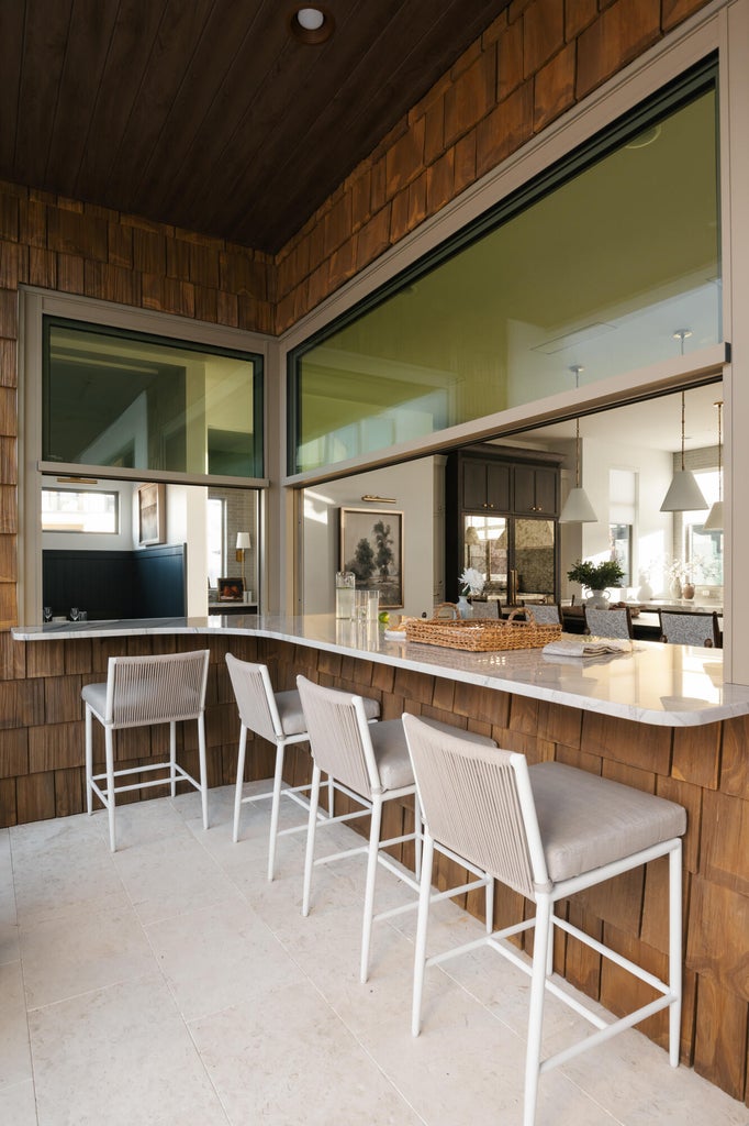 Outdoor bar area featuring a wood-shingle exterior, light-toned flooring, a light-colored countertop, and a dark wood-paneled ceiling