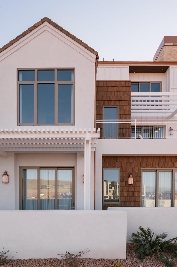 Multi-level exterior featuring white stucco, wood shake siding, and a tiled roof