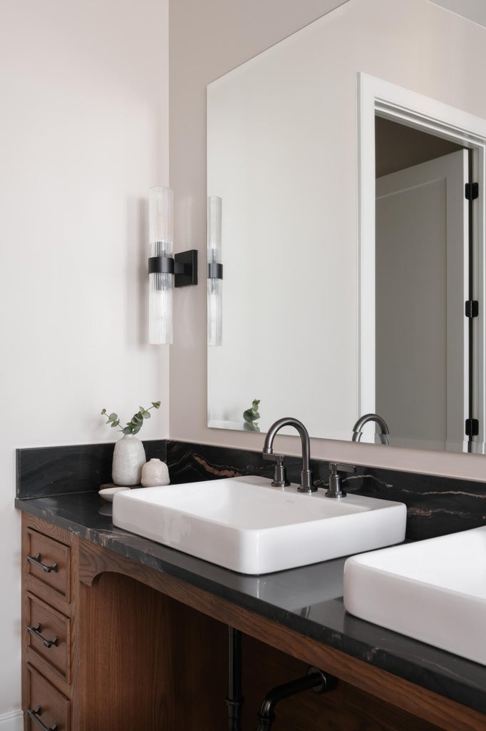 Dual rectangular vessel sinks with a dark countertop and wood-finish vanity