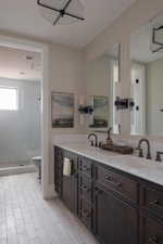 Dual vanity with dark wood cabinetry, white countertops, and matte black hardware