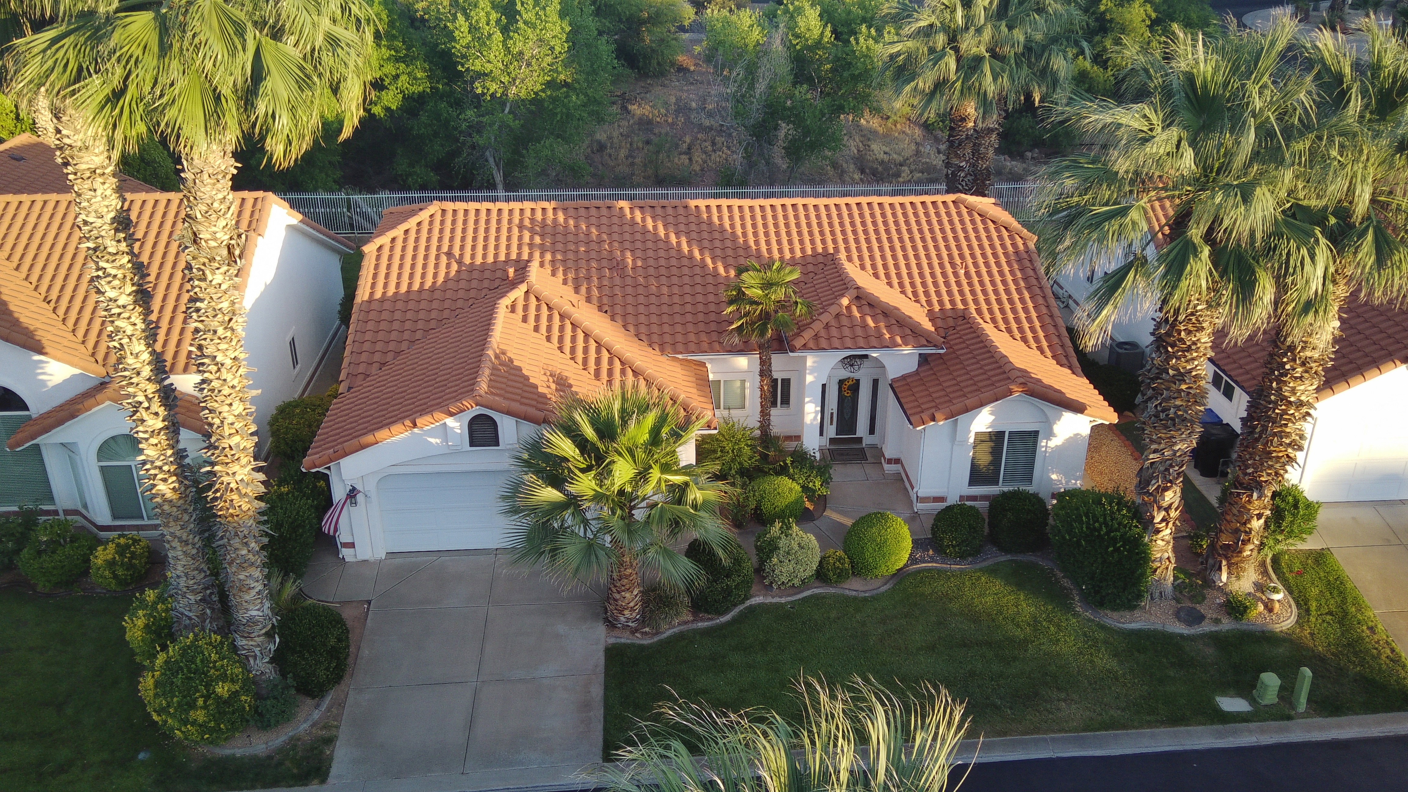 Spanish Colonial style residence featuring a terra cotta tile roof, a white stucco exterior, and arched window details