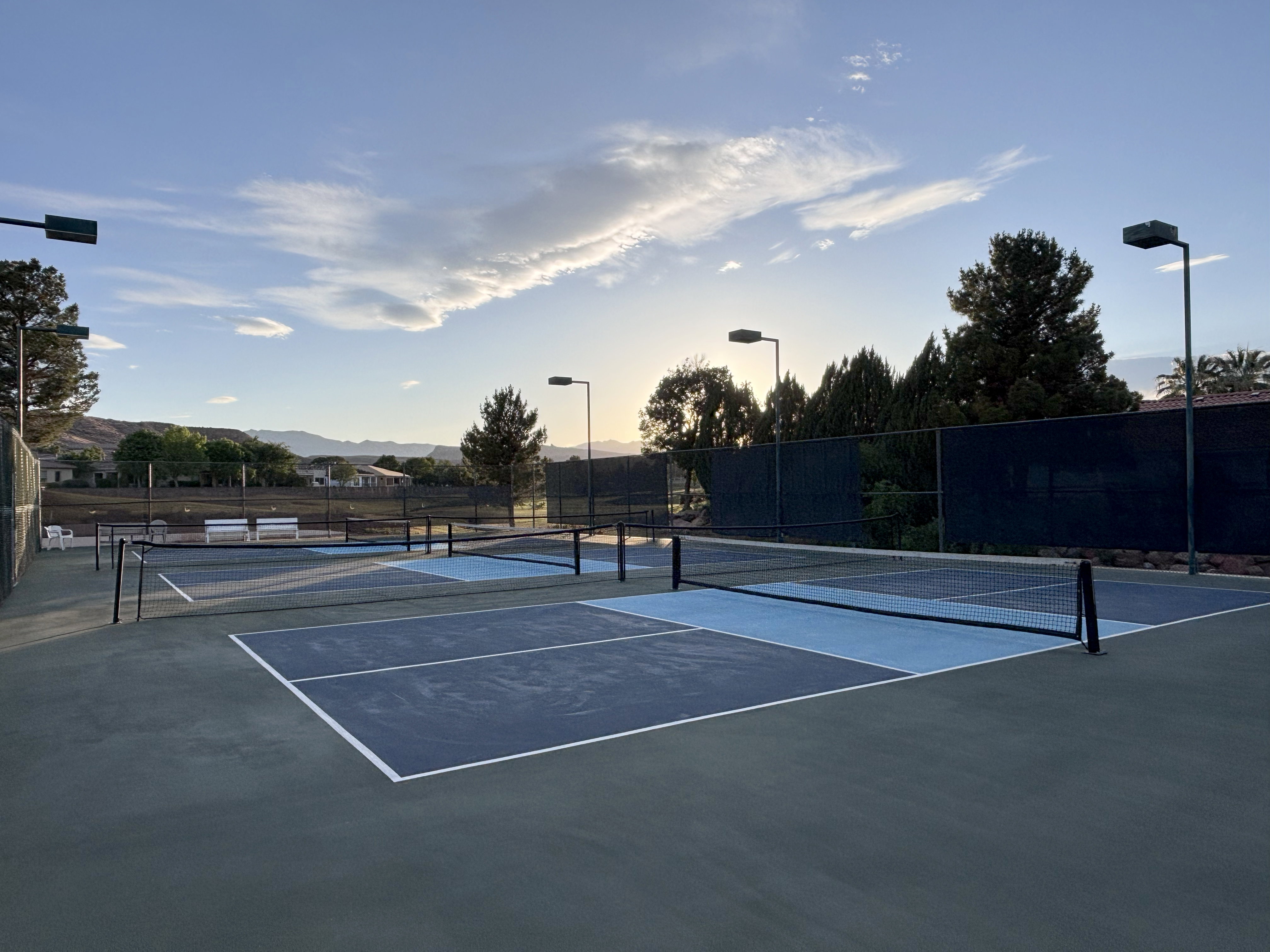 Multiple hard surface courts featuring regulation nets and clear court markings