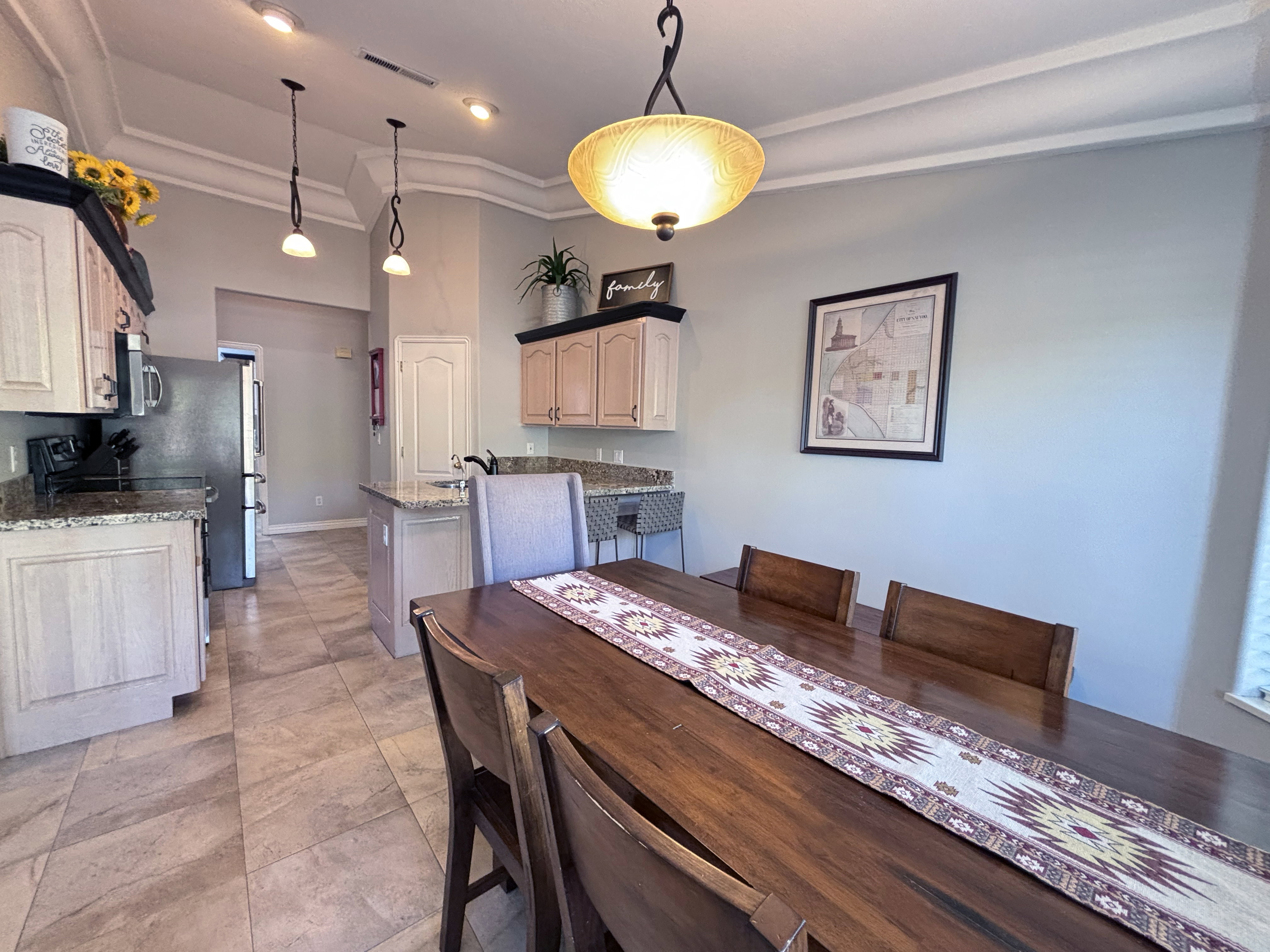 Open-concept kitchen and dining area featuring tile flooring, recessed lighting, and crown molding