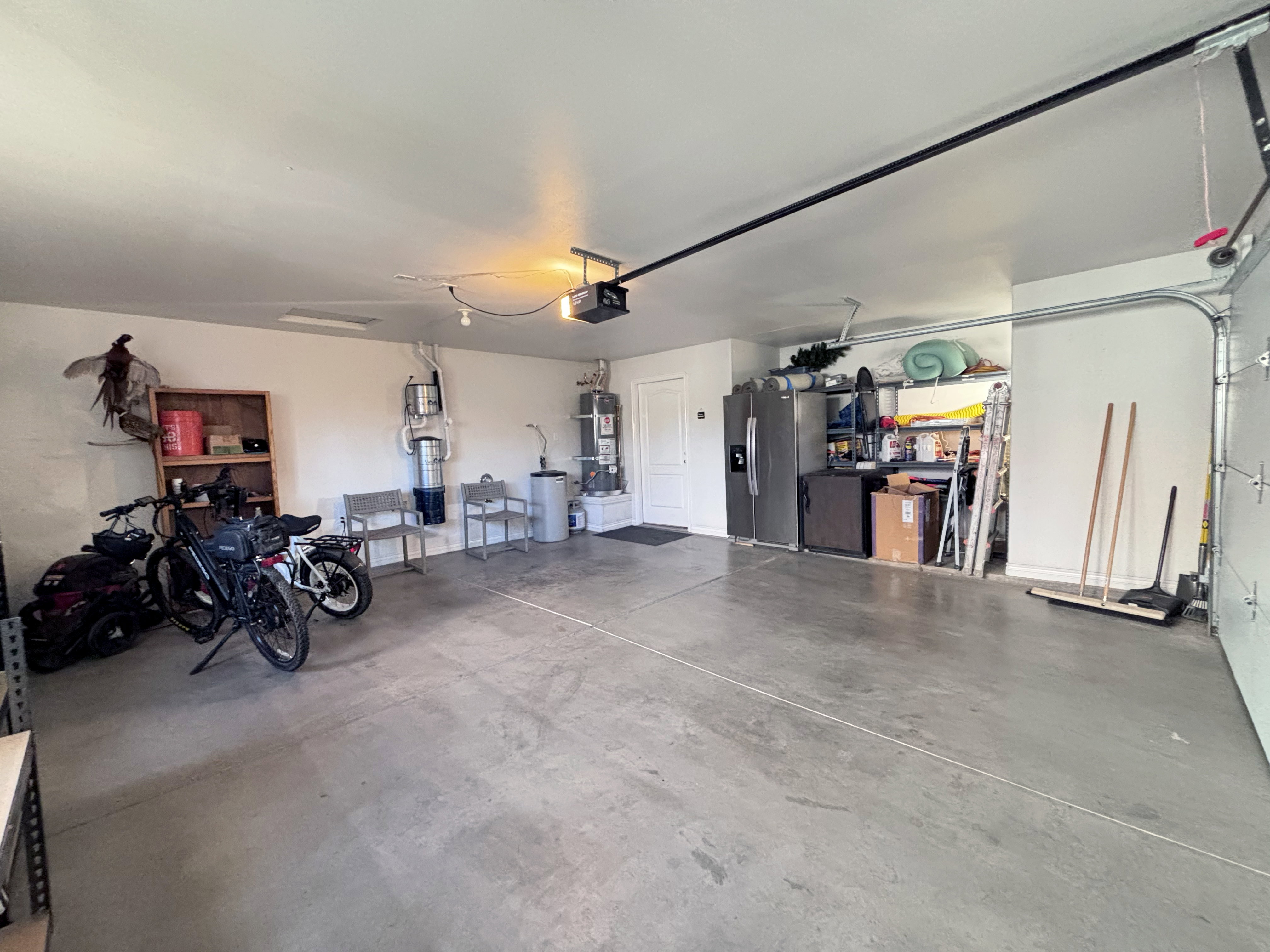 Spacious garage featuring a concrete floor, white painted walls, and an overhead garage door opener