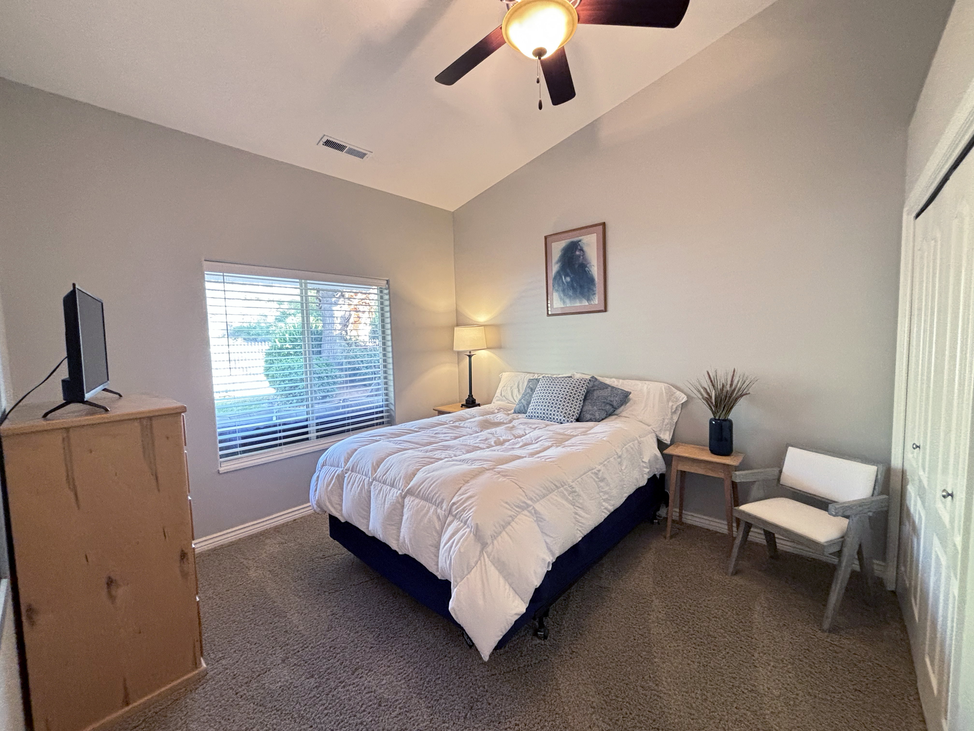 Bedroom featuring a vaulted ceiling and a ceiling fan with integrated lighting
