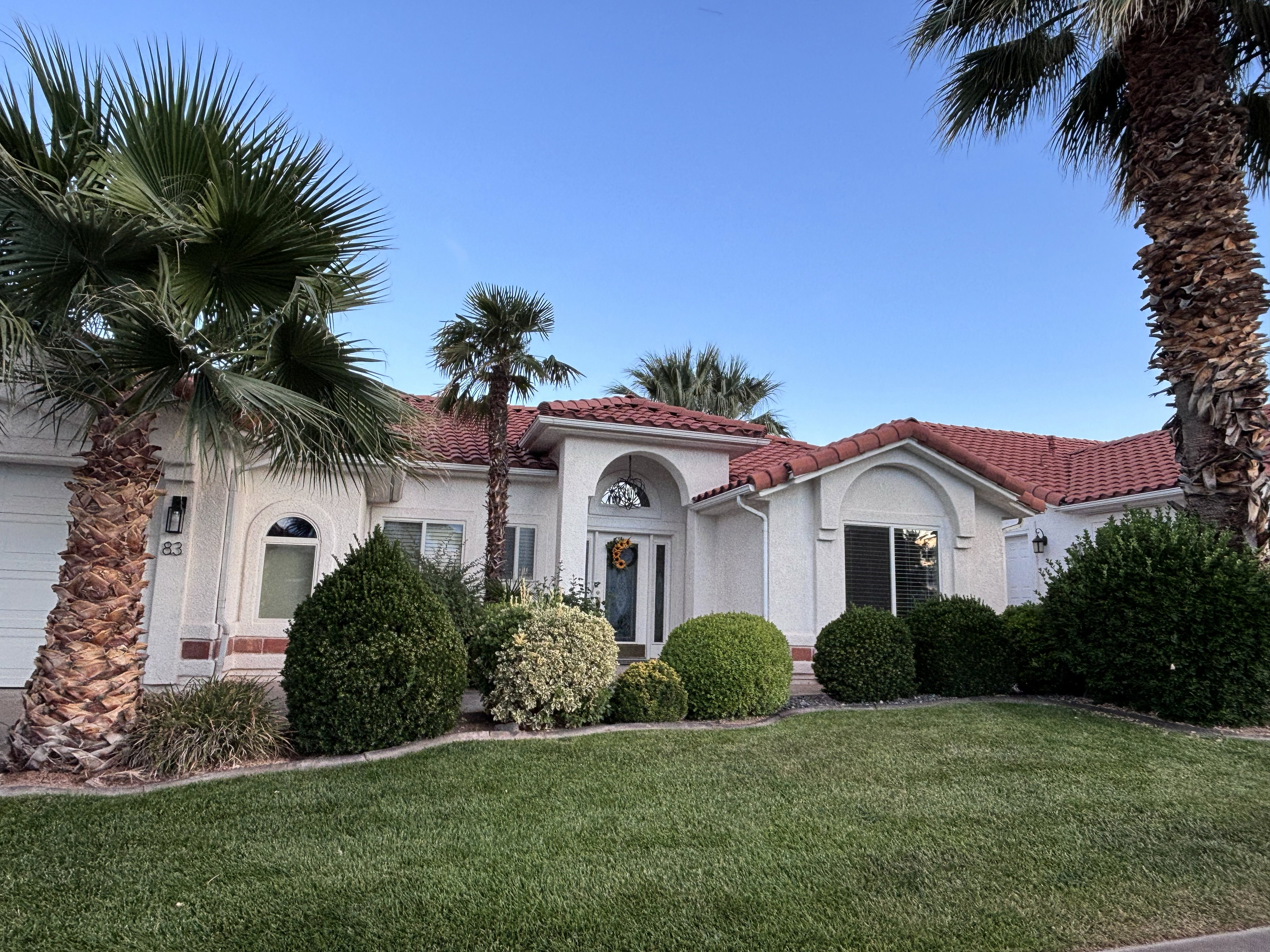 Spanish-style residence featuring a red tile roof and white stucco exterior