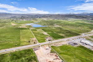 Expansive green acreage with distant mountains under a blue sky