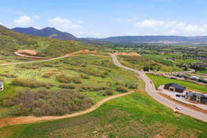 Expansive undeveloped land featuring rolling green hills and distant mountain ranges