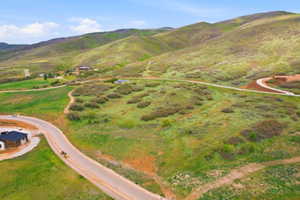 Expansive elevated terrain featuring rolling hills with natural foliage and established roadways