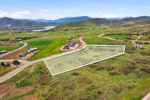 Expansive undeveloped land parcel featuring natural shrubbery and surrounding green hills