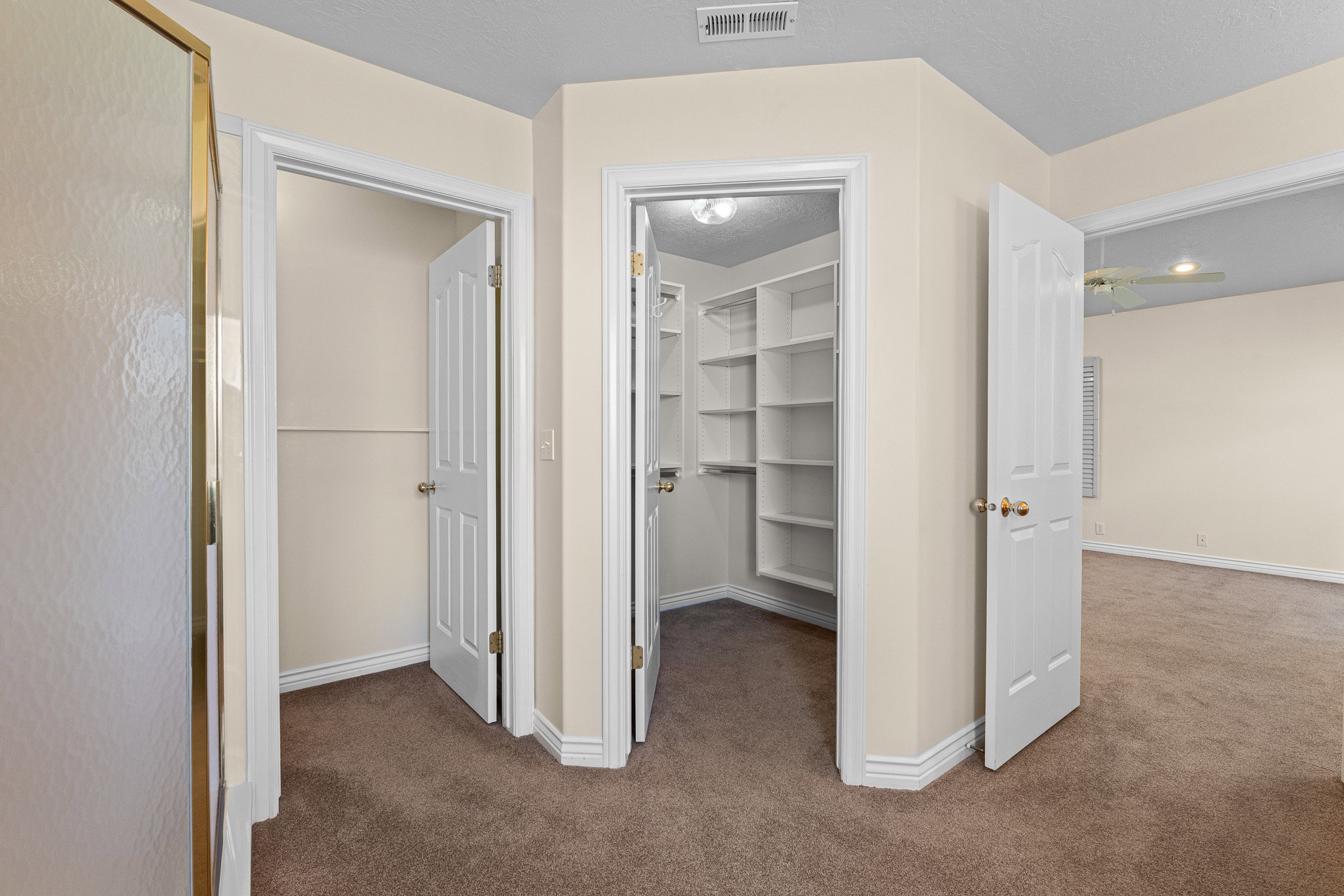 Walk-in closet with extensive built-in shelving, providing generous storage capacity