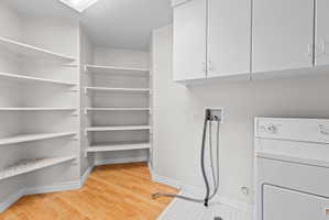 Dedicated laundry area featuring a white appliance hookup, upper cabinetry, and tile flooring