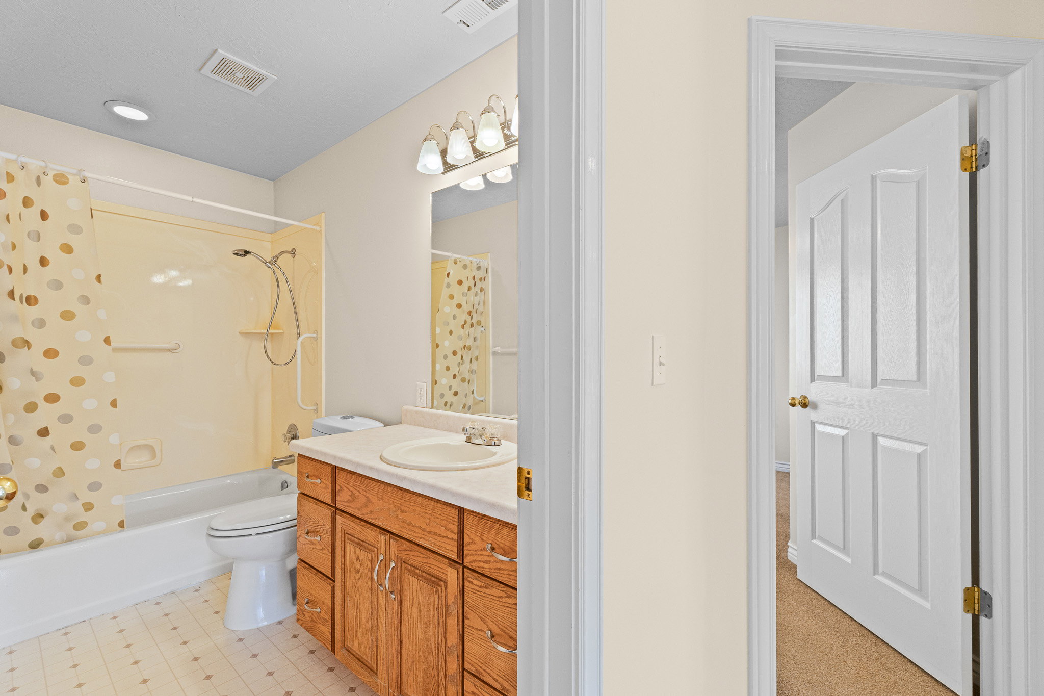 Full bathroom featuring a single vanity with wood cabinetry, a white countertop, and a white oval sink