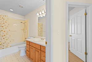 Full bathroom featuring a single vanity with wood cabinetry, a white countertop, and a white oval sink