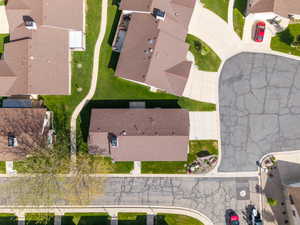 Aerial representation of a residential neighborhood featuring established homes with brown roofs, concrete driveways, and manicured lawns