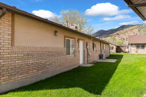 Exterior featuring a stucco and brick facade with brown gutters