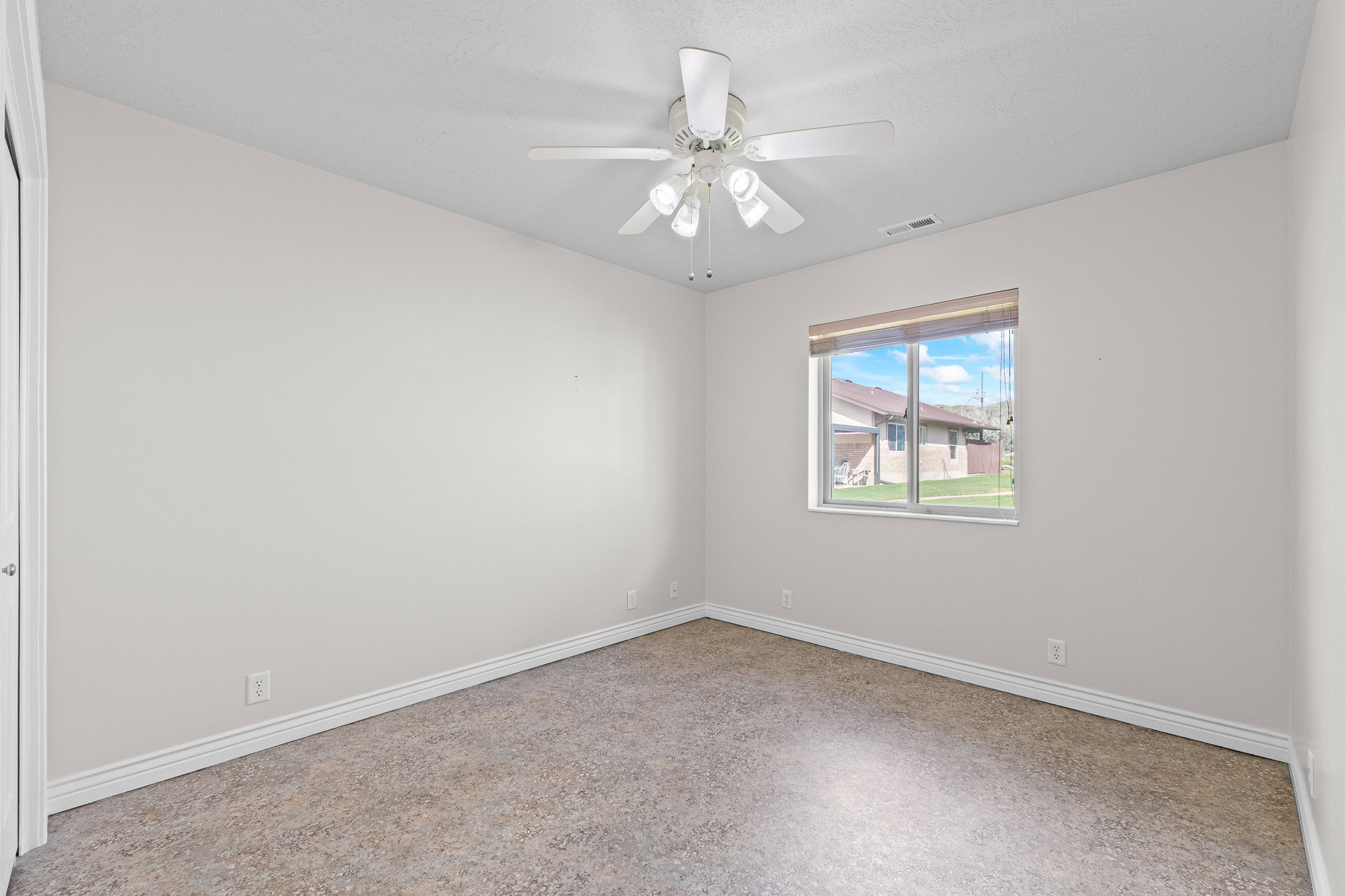 Light-filled room featuring a broad window, white trim, and neutral-toned carpet