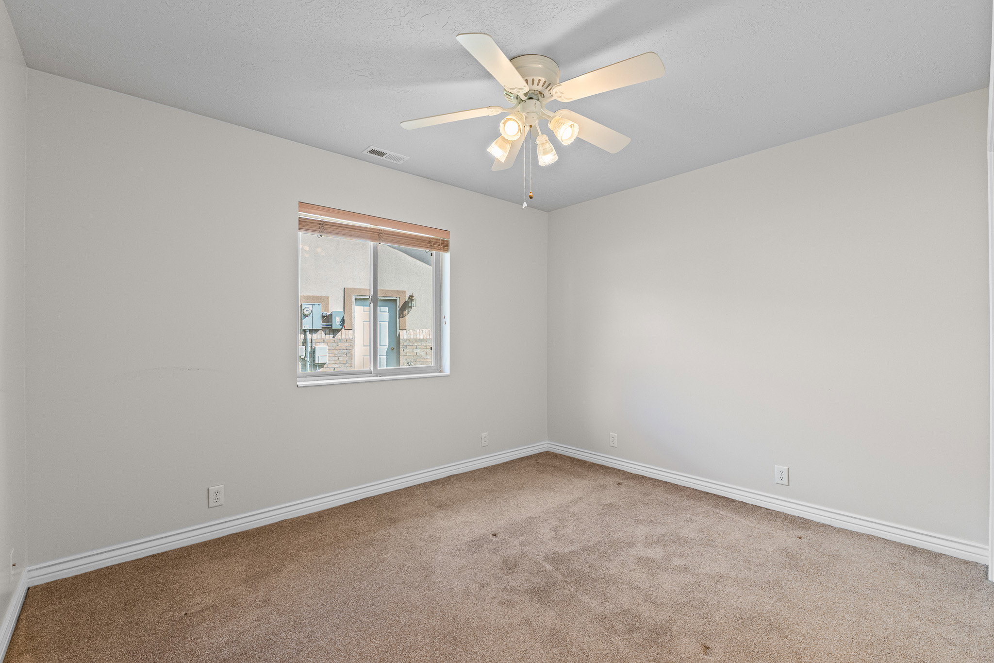Neutral-toned interior room featuring carpet flooring and white baseboards