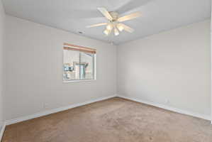 Neutral-toned interior room featuring carpet flooring and white baseboards
