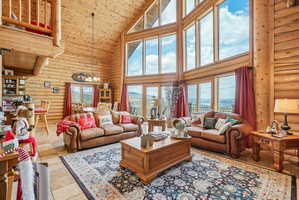 Vaulted living area featuring extensive natural wood log walls and ceilings