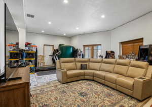 Spacious entertainment room featuring recessed lighting, a large area rug, and French doors