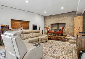 Spacious room featuring a stone-block accent wall, a built-in wood-burning stove, and a natural wood door