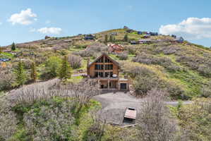 Rustic-modern residence featuring a prominent A-frame design, extensive window walls, and wood-finish siding