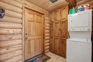 Natural wood-paneled door framed by log walls and a log ceiling