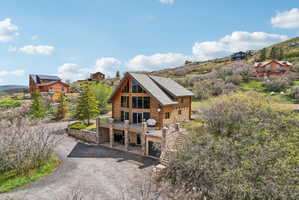Rustic-style home featuring a log exterior and a prominent A-frame architectural element