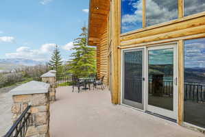 Expansive outdoor patio area featuring a concrete surface, stone pillar accents, and black metal railings