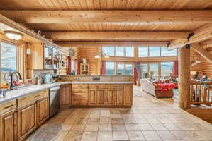 Open-concept kitchen featuring wood cabinetry, stainless steel appliances, and a tiled backsplash