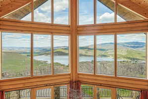 Expansive wall of windows showcasing panoramic lake and mountain scenery